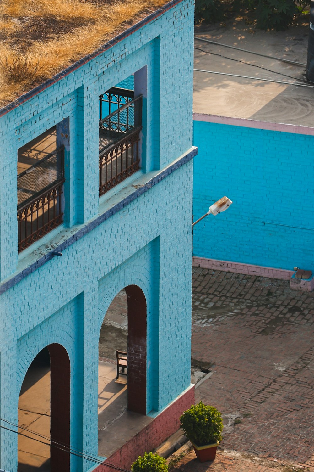 um edifício azul com um telhado verde ao lado de uma piscina
