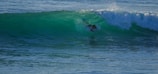 Surfer catching a perfect wave at sunrise on Playa El Tránsito