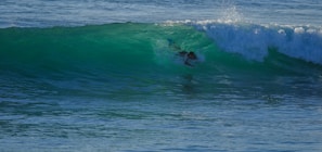 Surfer catching a perfect wave at sunrise on Playa El Tránsito