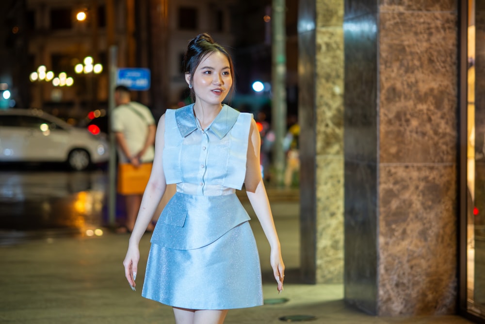 a woman walking down a street at night