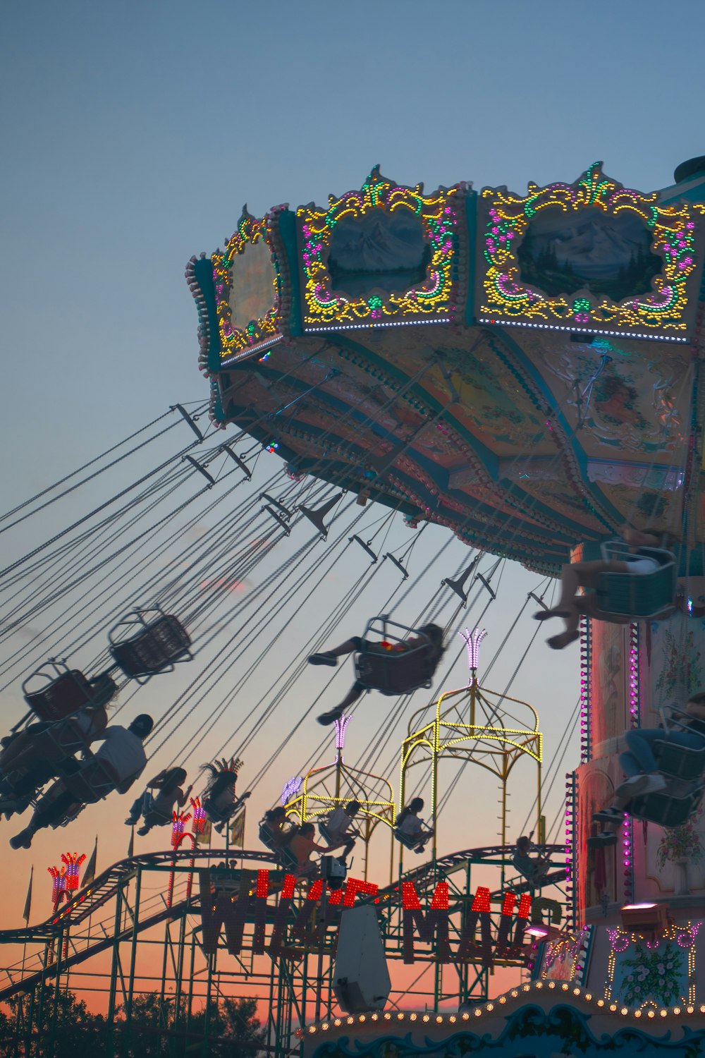 a carnival ride at dusk with people on it