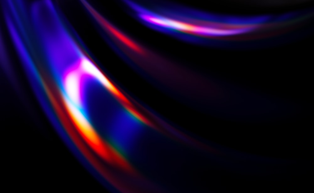a black background with a multicolored wave of light