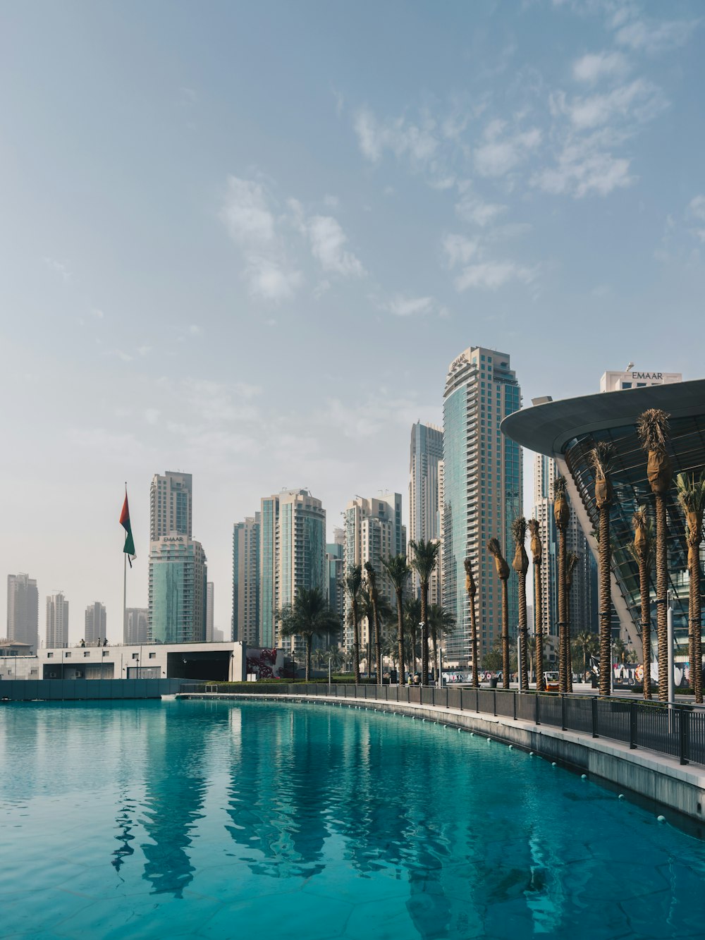 a large swimming pool in front of a city skyline