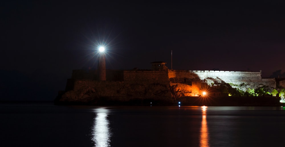 um grande castelo iluminado à noite com luzes acesas