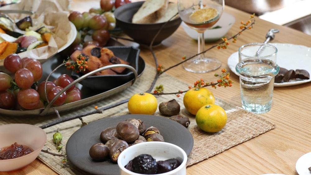 a wooden table topped with plates and bowls of food