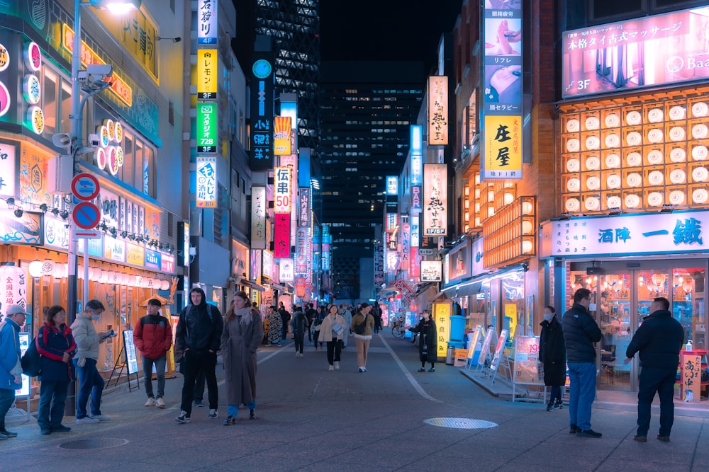 a group of people walking down a street next to tall buildings