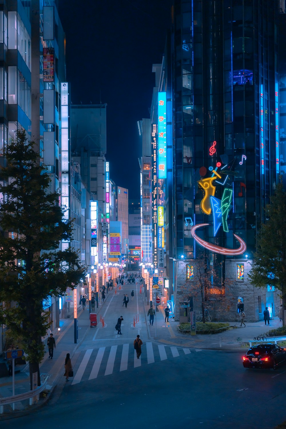 a city street at night with people walking on it