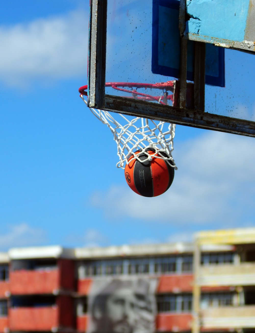 a basketball going through the net of a basketball hoop