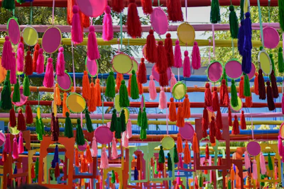 Elegant tassel-themed sangeet setup with colorful hanging tassels creating a playful backdrop.