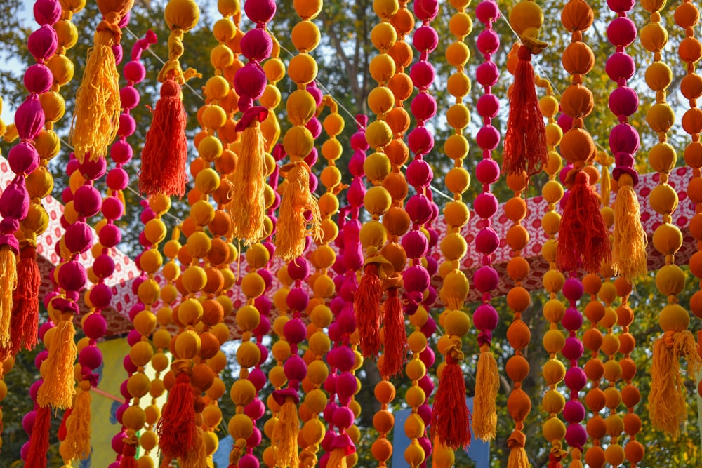 a bunch of orange and pink balls hanging from a tree