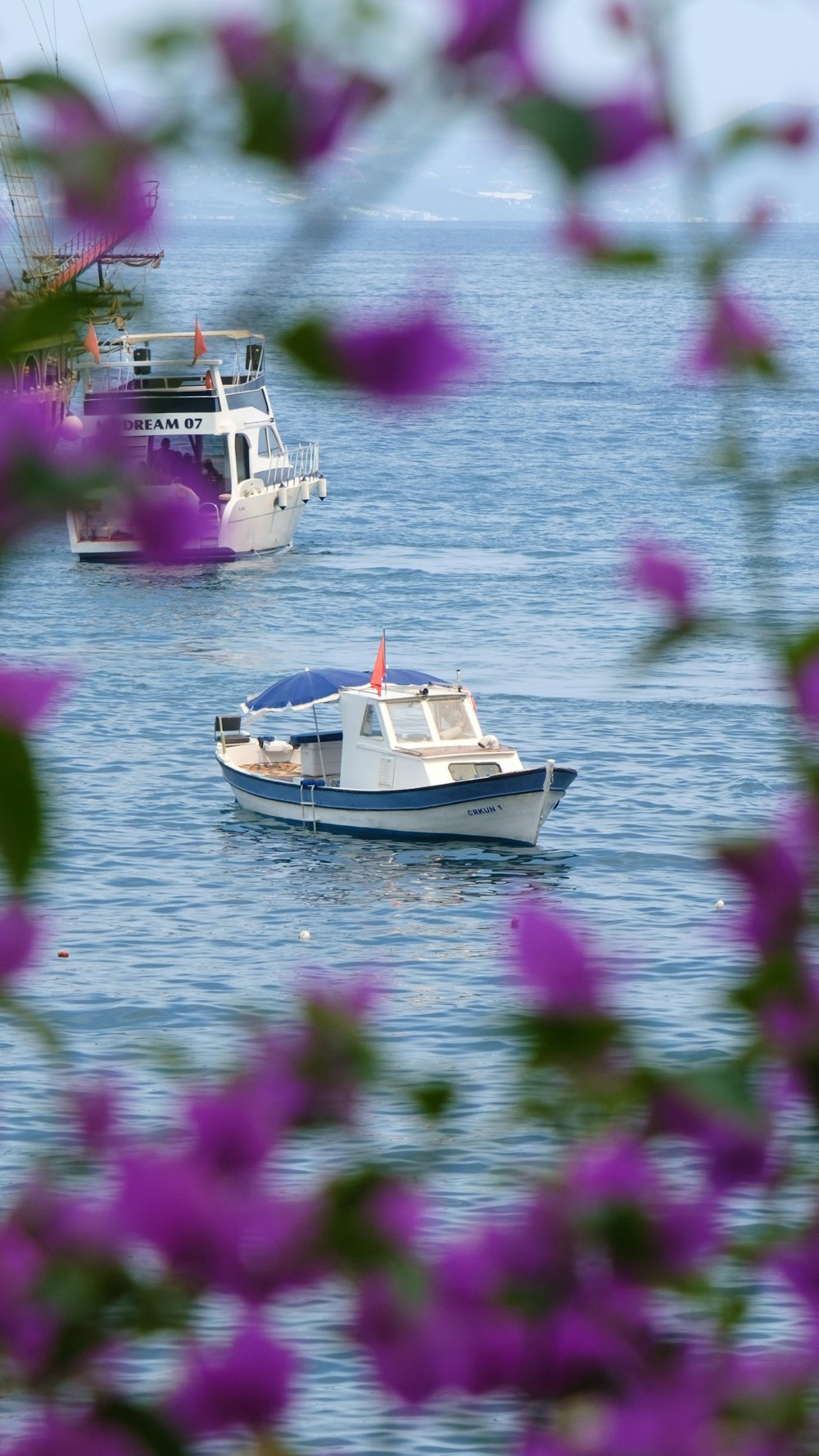 a couple of boats floating on top of a body of water