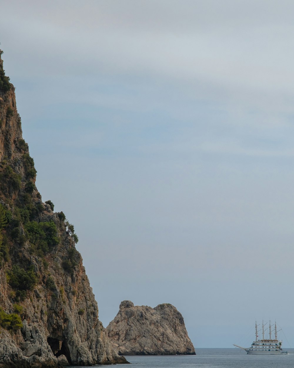 a boat is in the water near a rocky cliff