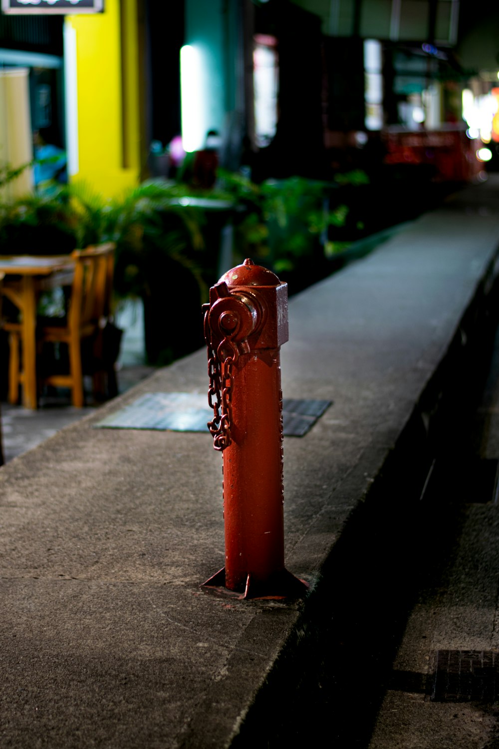 a red fire hydrant sitting on the side of a sidewalk