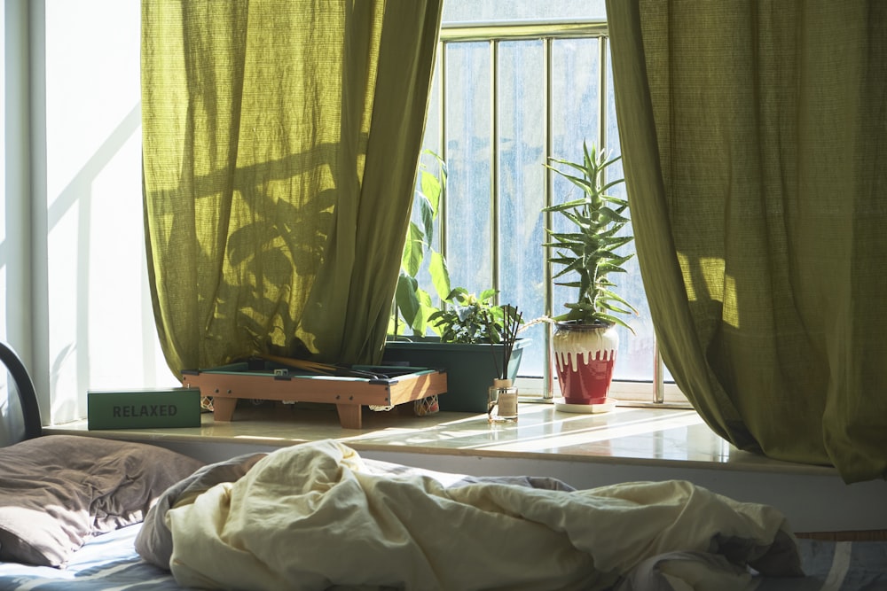 a bedroom with a bed and a green curtained window