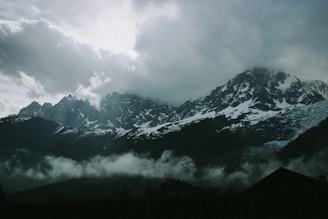 a mountain range covered in clouds and snow
