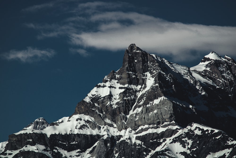 ein sehr hoher, schneebedeckter Berg unter einem bewölkten Himmel