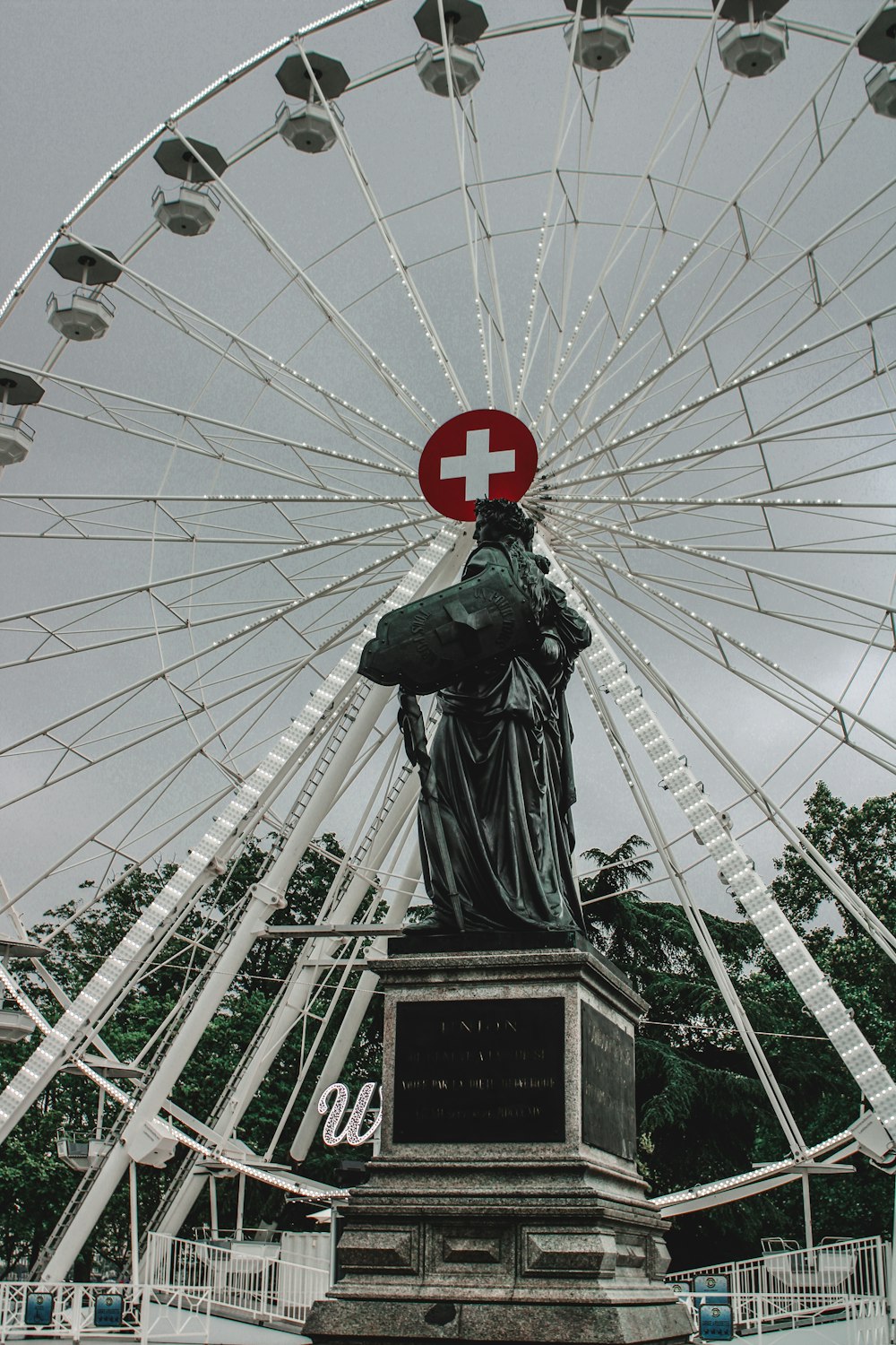 une grande roue avec une statue devant elle