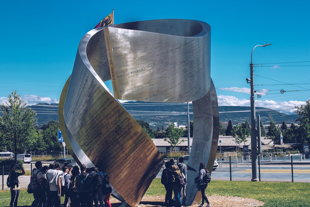 a group of people standing around a large metal object