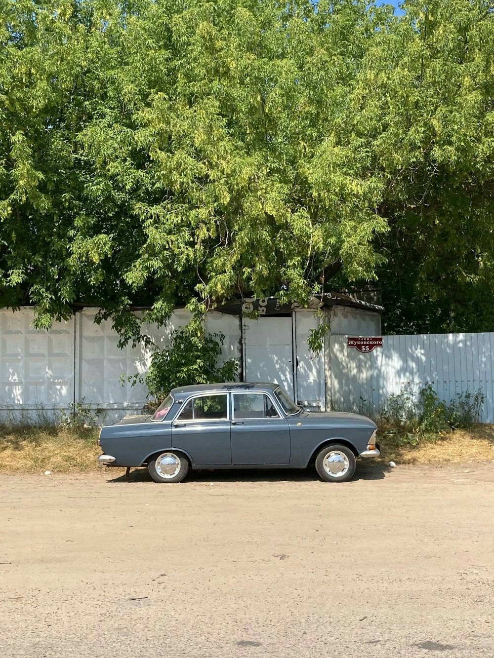 a car parked in front of a white fence