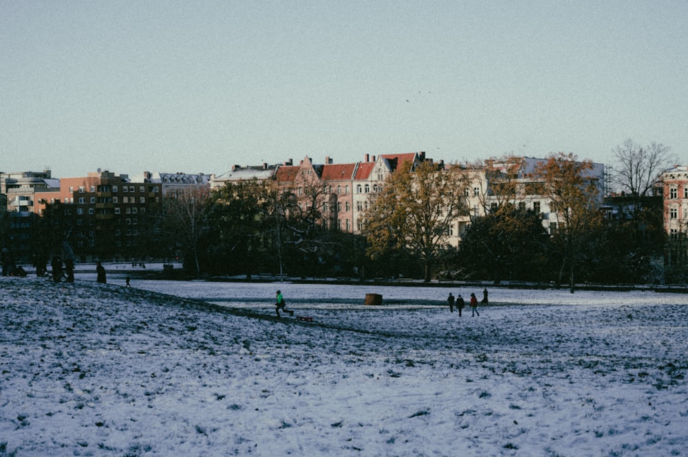 a group of people walking across a snow covered field