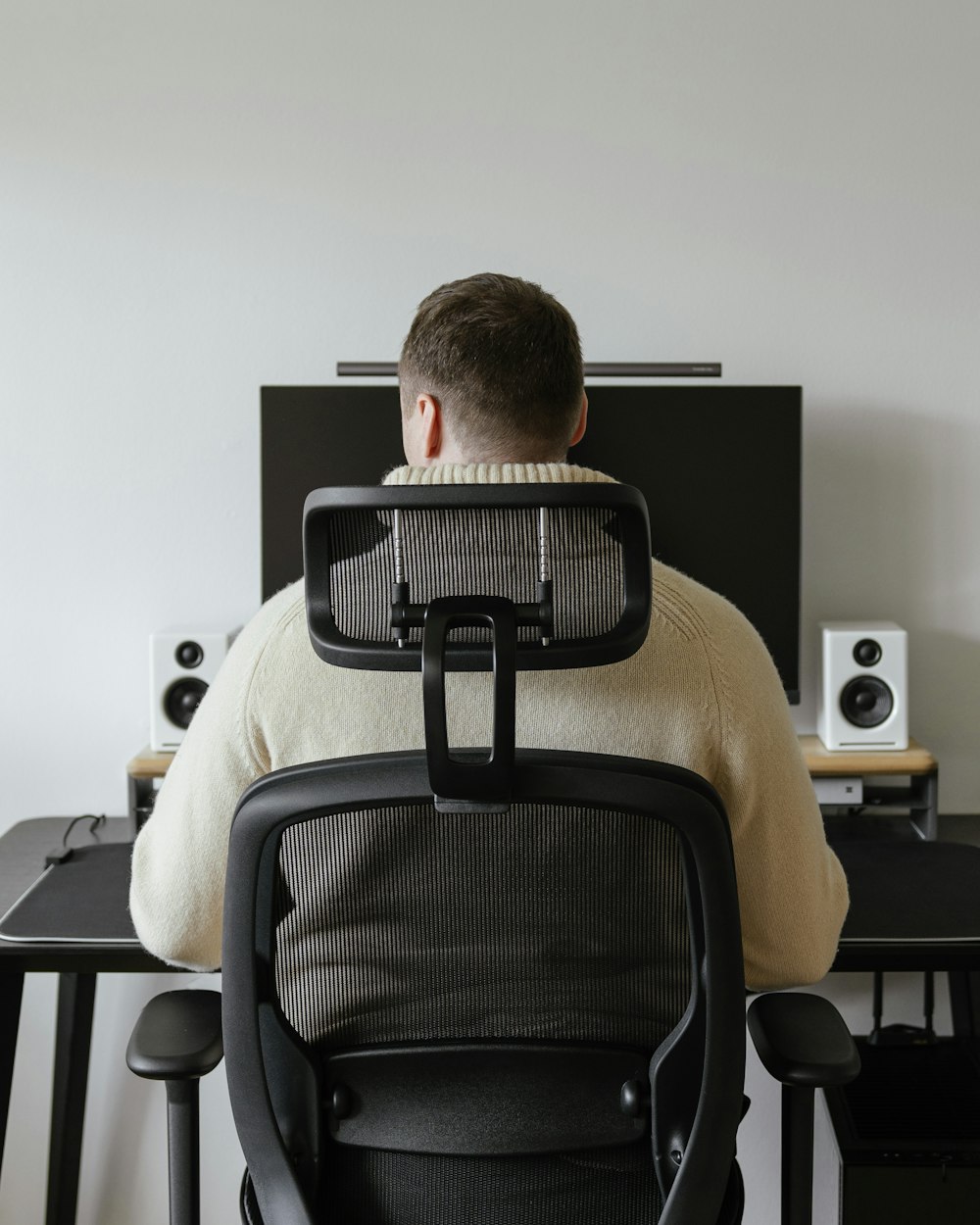 a man sitting at a desk with his back to the camera