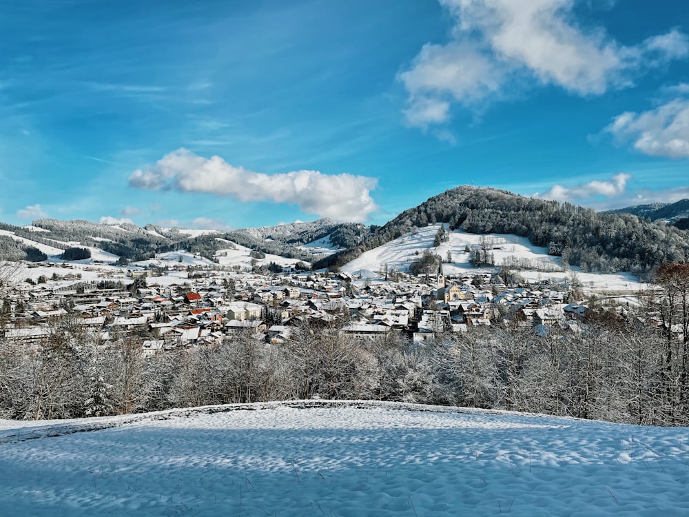 a view of a town in the mountains covered in snow