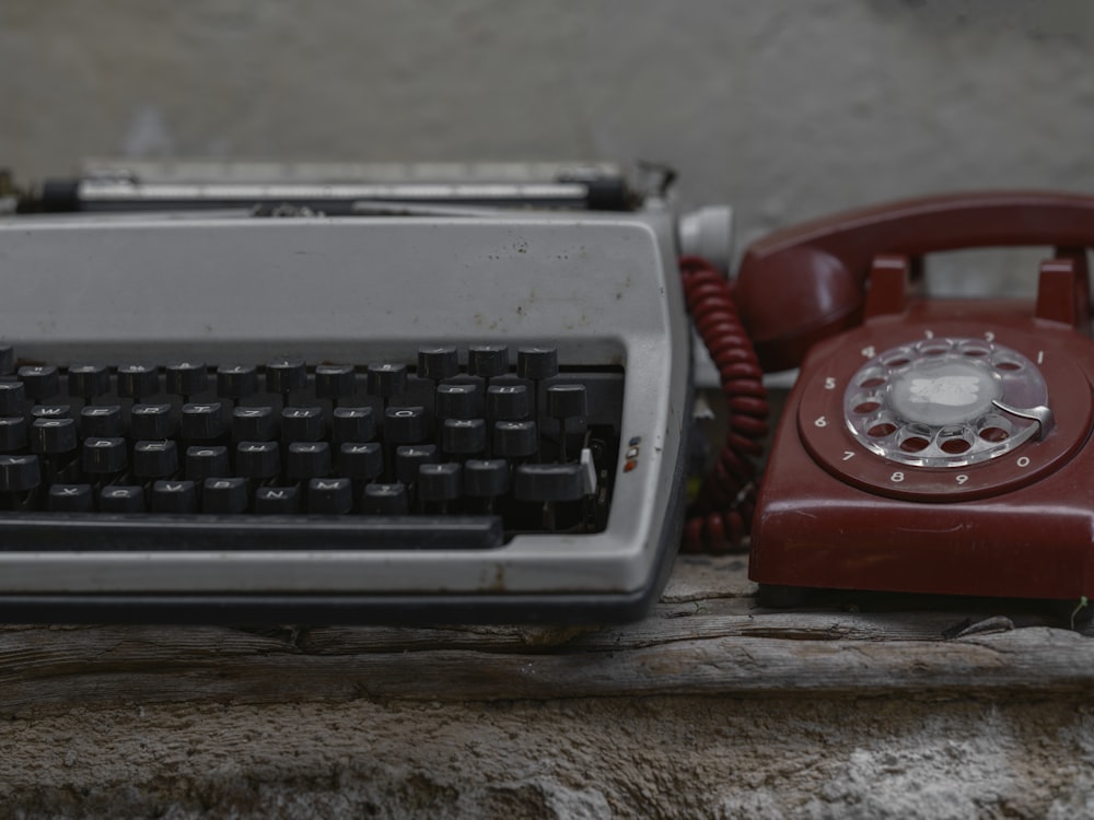 un teléfono rojo y una máquina de escribir roja sobre una mesa