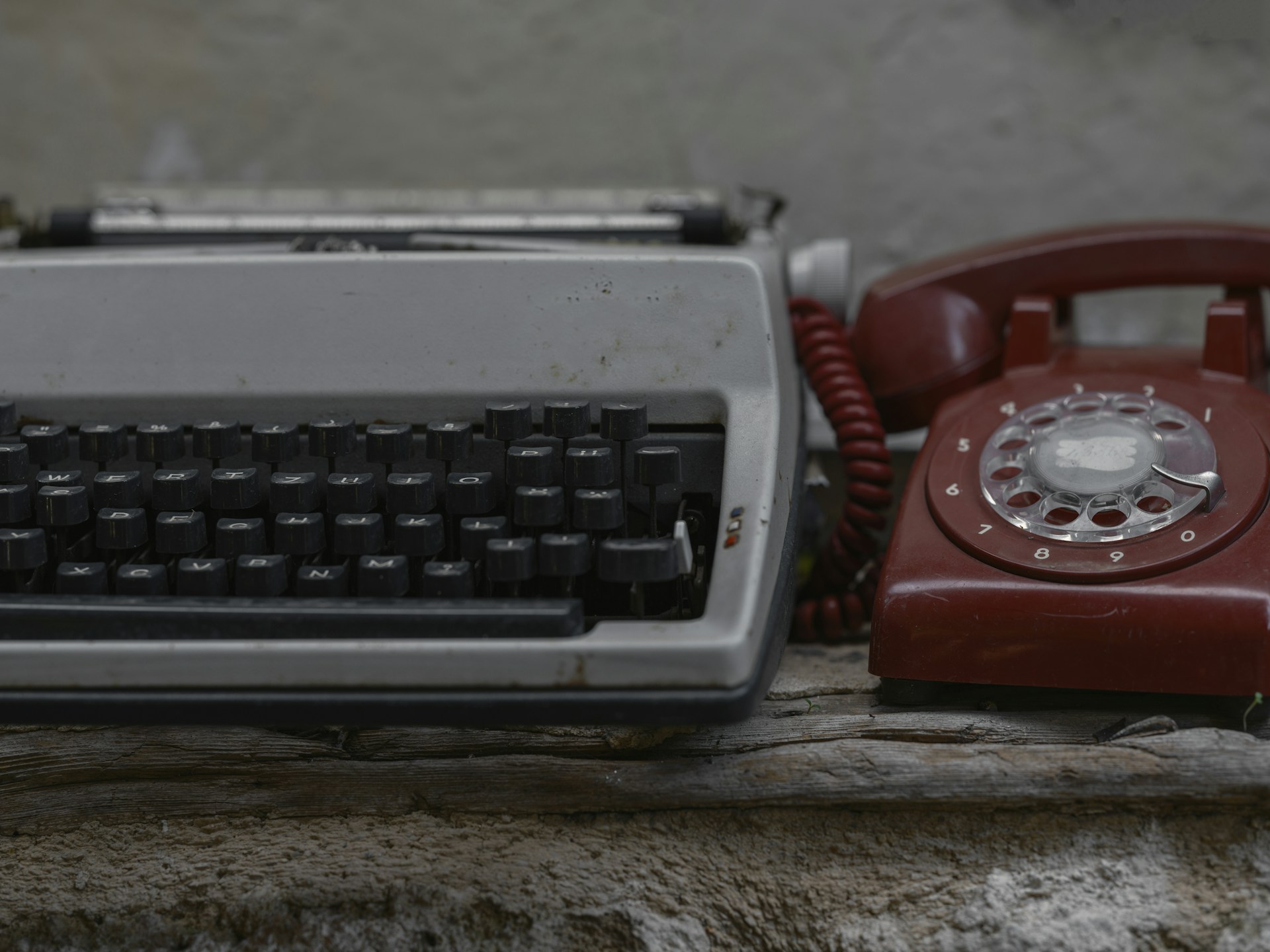 a red telephone and a red typewriter on a table