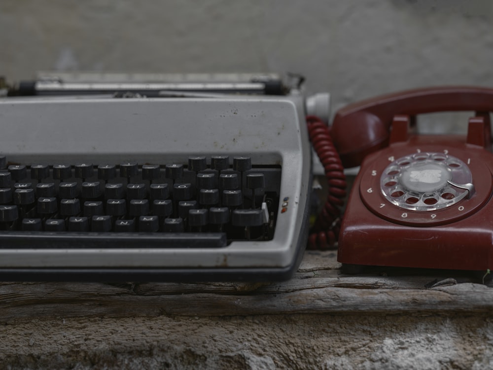 a red telephone and a red typewriter on a table