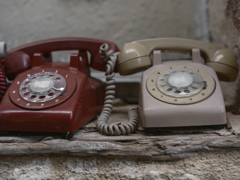 two old fashioned telephones sitting on a table