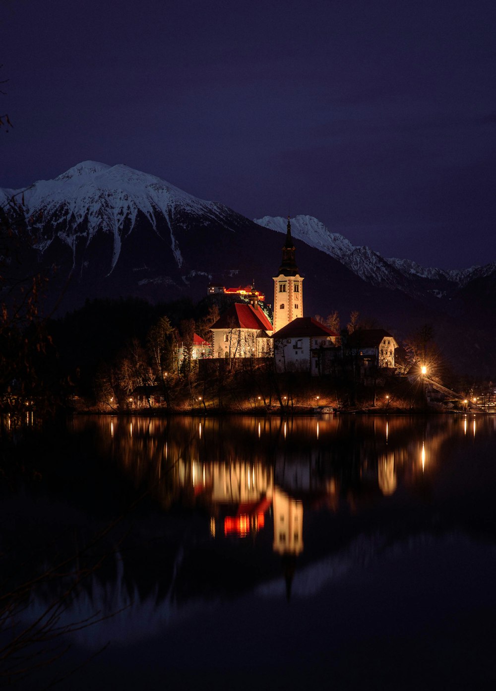 a lake with a church on a hill in the background