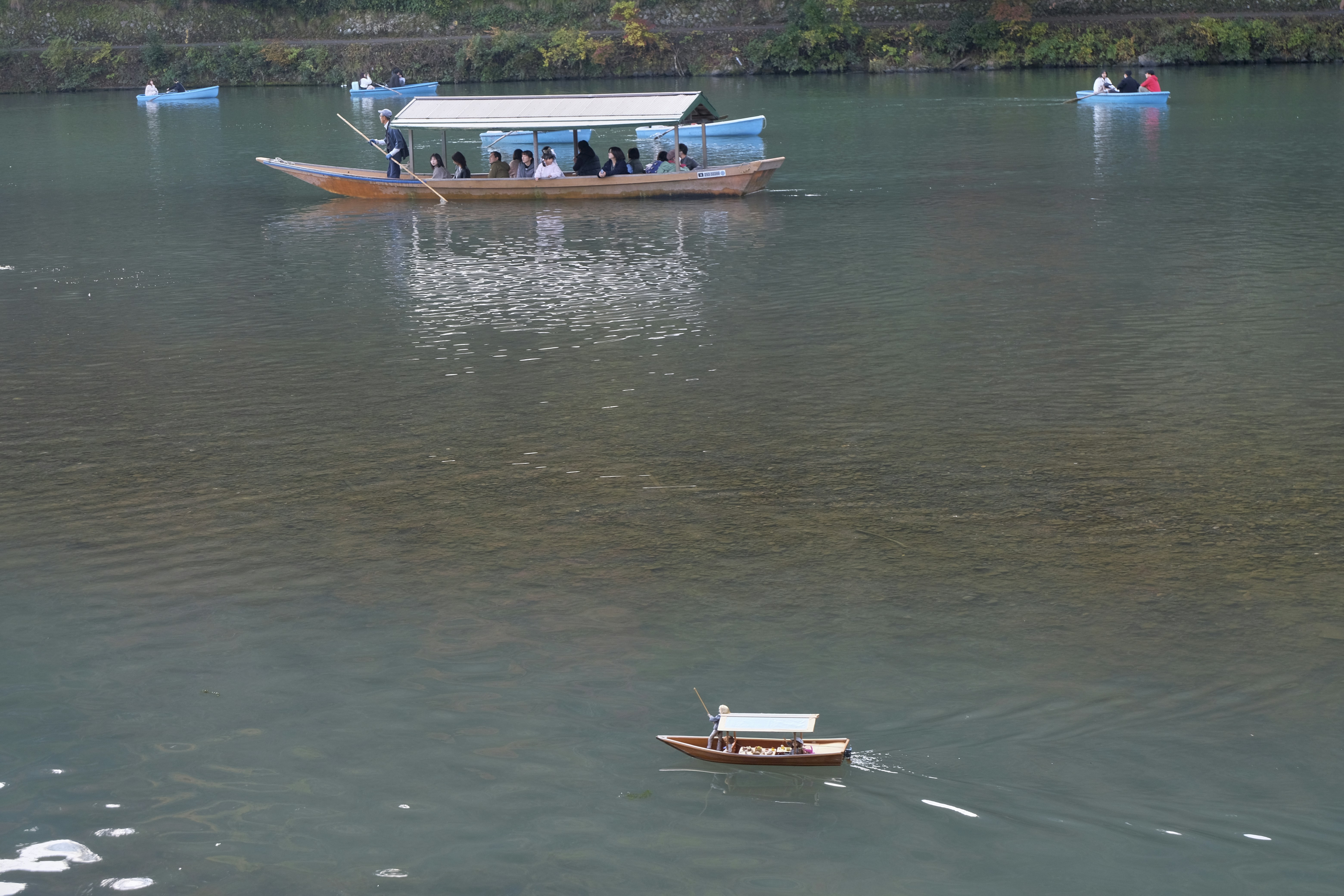 Drift boat on calm river with forested banks in Arkansas