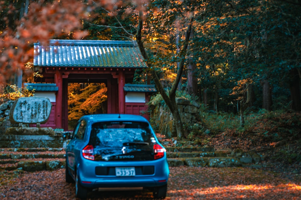 a blue car parked in front of a red building