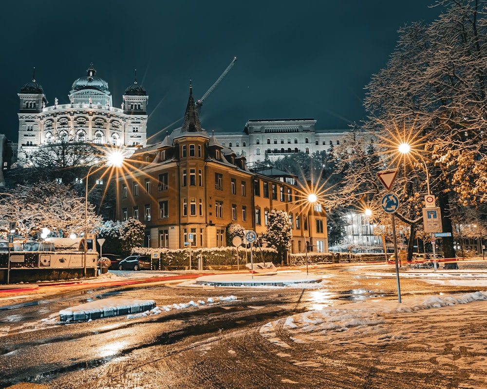 a city street at night with snow on the ground