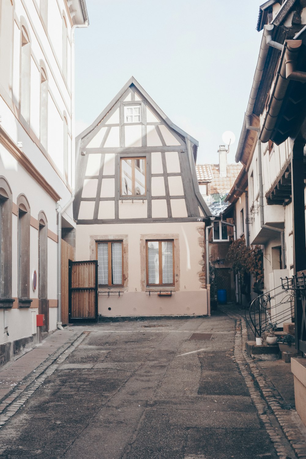 uma rua estreita com um edifício de madeira no fundo