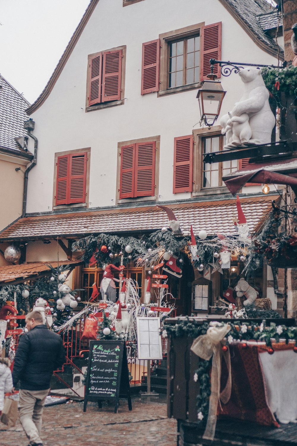 a person walking in front of a building with christmas decorations