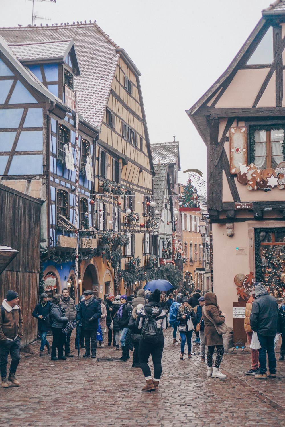 a group of people walking down a cobblestone street