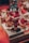 Several Santa Claus figures are displayed, with one performing a headstand on a rotating base. The Santas are dressed in traditional red suits with white fur trim, surrounded by festive decorations including a bearded figure in the background holding an accordion.