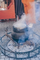 a person standing over a pot on top of a grill