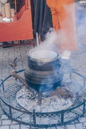 a person standing over a pot on top of a grill