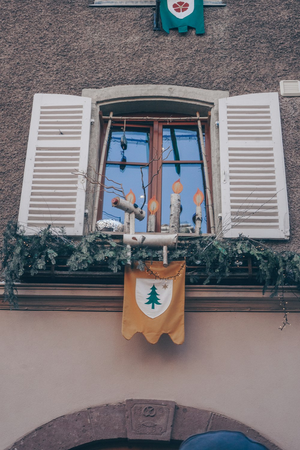 a window with a christmas decoration hanging from it's side