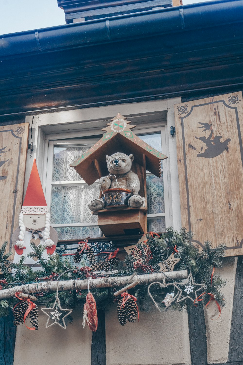 a teddy bear sitting on top of a window sill