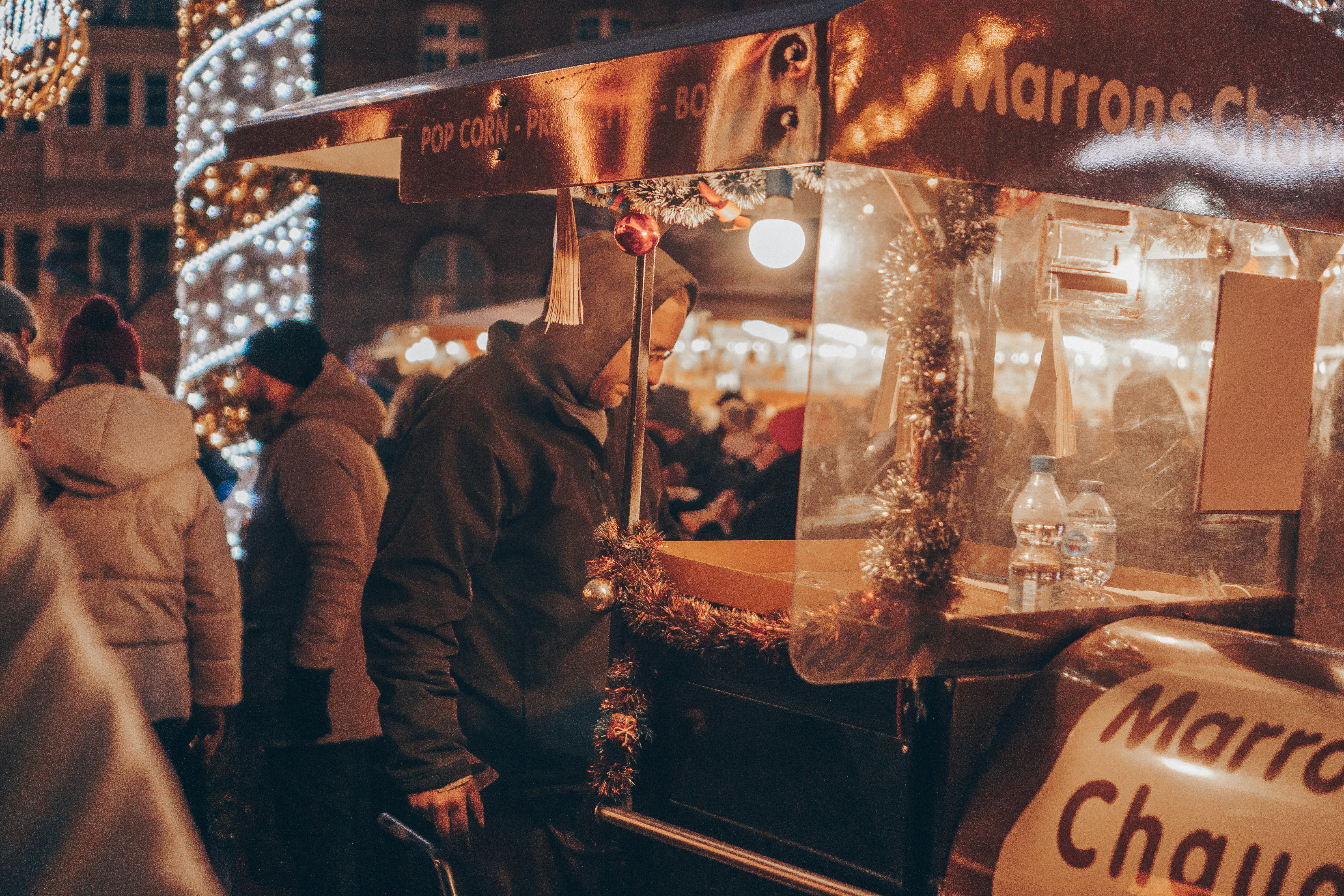a group of people standing around a food cart