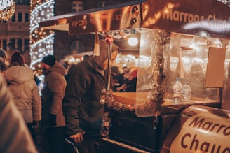 a group of people standing around a food cart