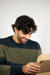A candid shot of a fan unboxing their Reelist Enterprise merch with excitement.
