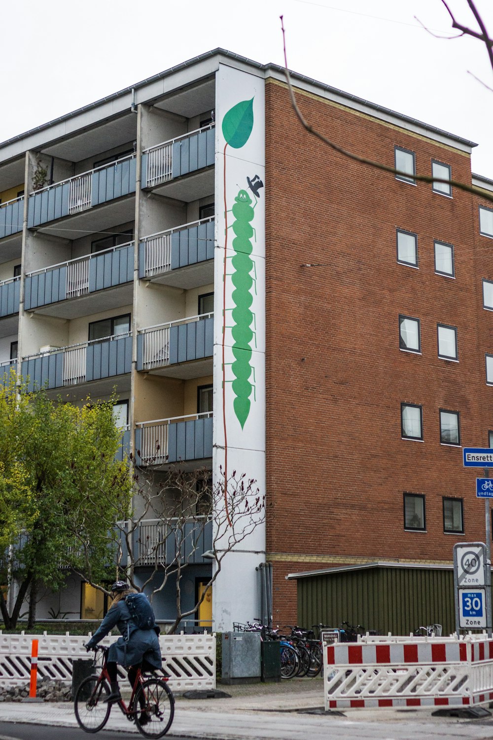 a man riding a bike past a tall building