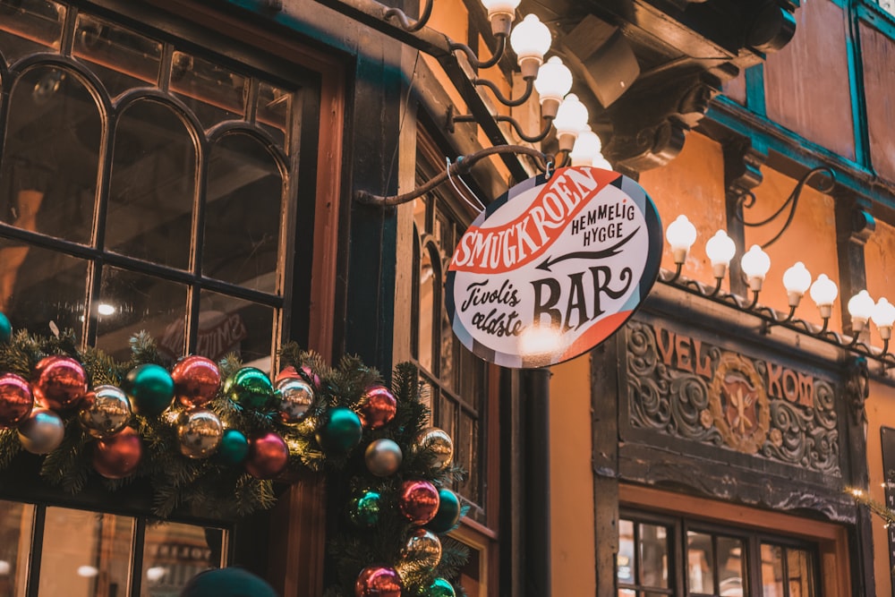 a store front with a christmas wreath and a neon sign