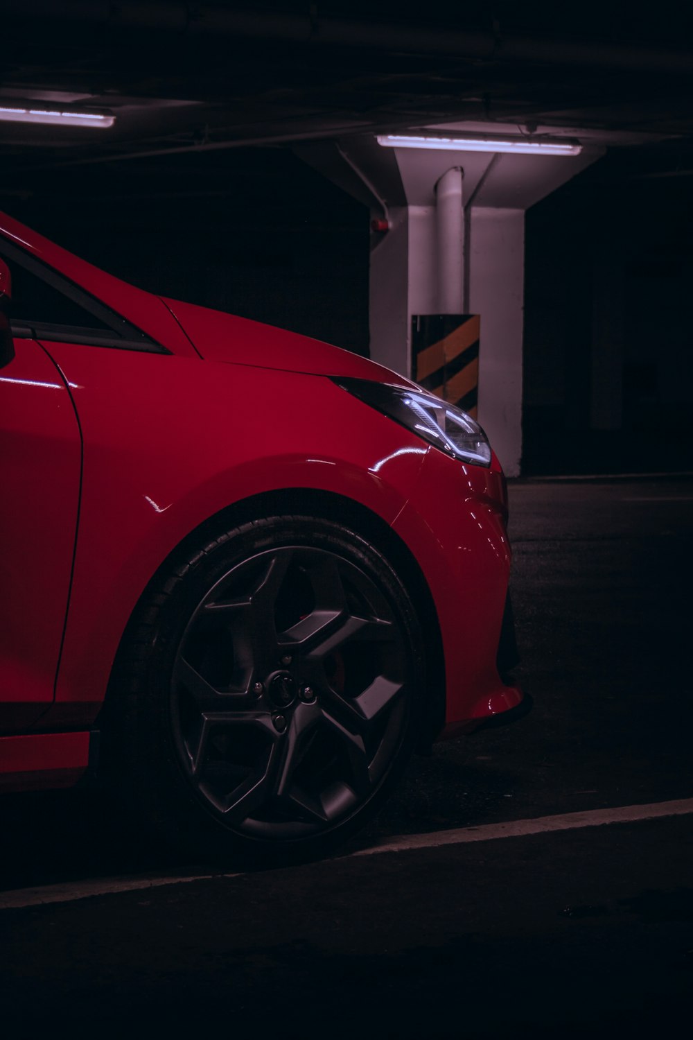 a red car parked in a parking garage