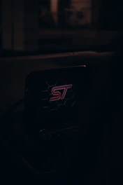 A sleek car dashboard featuring a Soultag device glowing electric blue, highlighting vehicle security.