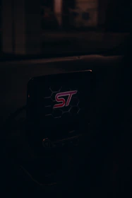 A sleek car dashboard featuring a Soultag device glowing electric blue, highlighting vehicle security.